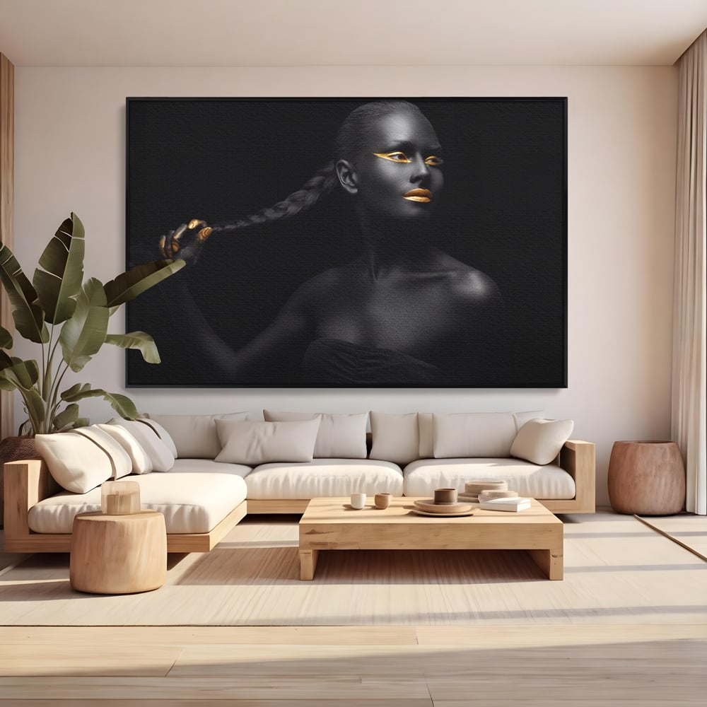 Tablou canvas cu tablou canvas cu femeie vopsita in negru si auriu, in rama de aluminiu negru, pe perete intr-un living